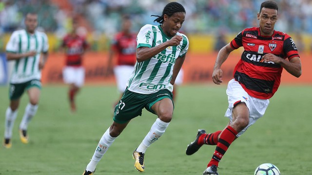 jogadores do Palmeiras e do Atlético Goianiense disputam bola em meio a partida