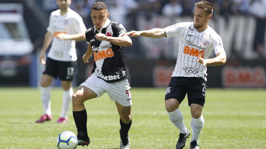 jogadores do Vasco e do Corinthians usando uniformes preto e branco disputando bola em campo