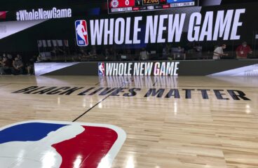 imagem de quadra de basquete dentro da bolha da disney com letreiro escrito "whole new game"