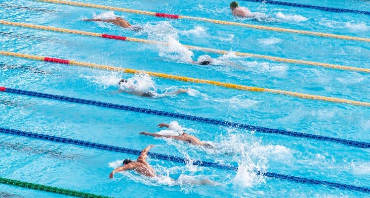 Vários competidores estão nadando em uma piscina