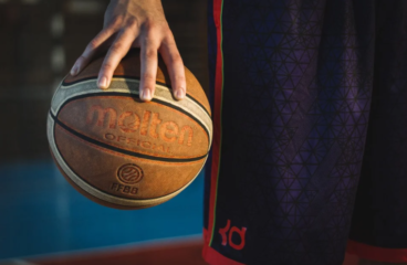 imagem ampliada de mão de pessoa segurando uma bola de basquete